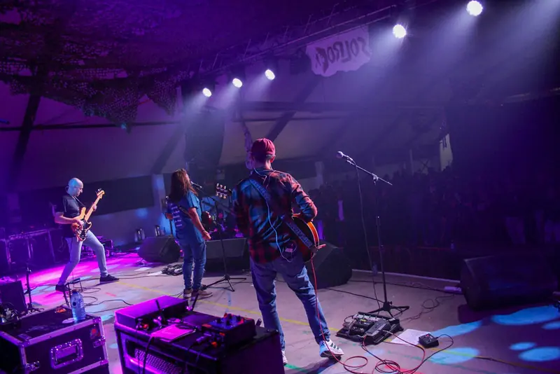 Banda tocando en el escenario de Solrock bajo luces moradas